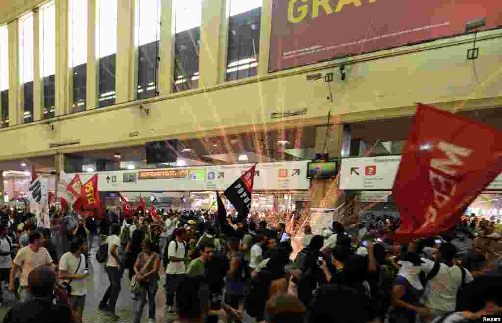 A firework explodes as members of the "Free Pass" movement invade the Central Train Station to demand zero tariffs in the Brazilian public transport system in Rio de Janeiro, Feb.6, 2014.