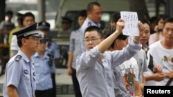 一名警察星期二在北京的日本大使館外對示威抗議者發話