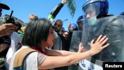 Des officiers de police et des manifestants s'affrontent lors d'une manifestation du 1er mai à Alger, en Algérie, le 1er mai 2019. 