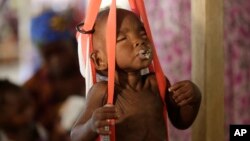 FILE- A malnourished child is weighed on a scale at a clinic run by Doctors Without Borders in Maiduguri, Nigeria, Aug. 29, 2016.
