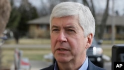 FILE - Michigan Gov. Rick Snyder is interviewed after visited a church that's distributing water and filters to its predominantly Latino parishioners in Flint, Feb. 5, 2016.