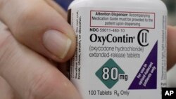 FILE - Pharmacist Steve Protzel holds a bottle of OxyContin in San Francisco, April 2, 2018. 