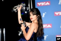 Camila Cabello poses with her awards for artist of the year and video of the year for "Havana" in the press room at the MTV Video Music Awards at Radio City Music Hall on Monday, Aug. 20, 2018, in New York.