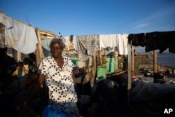 Yolaine Casimir stands in her destroyed house caused by Hurricane Matthew, in Jeremie, Haiti, Oct. 8, 2016.