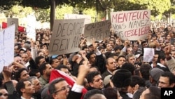 Tunisians shout slogans as they demonstrate against Tunisian President Zine al-Abidine Ben Ali in Tunis, 14 Jan 2011