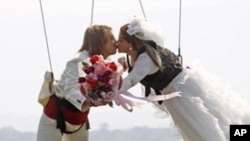 Thai-Swedish couple William Timhede, 23, left, and Napatsawan Timhede, 39, kiss as they hang on sling wireas part of an adventure-themed wedding ceremony in Thailand, on Monday, Feb. 13, 2012, on the eve of Valentine's Day.