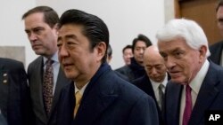Japanese Prime Minister Shinzo Abe, center, is greeted by Chairman and Cisco CEO Chuck Robbins, left, and U.S. Chamber of Commerce President and CEO Tom Donohue, right, as he arrives to speak at a business roundtable at the U.S. Chamber of Commerce in Washington, Feb. 10, 2017.