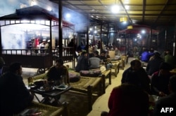 Pakistani patrons enjoy eating grilled meat cooked on a barbeque at the Charsi (Hashish) Tikka restaurant in Namak Mandi in Peshawar, Dec. 6, 2018.