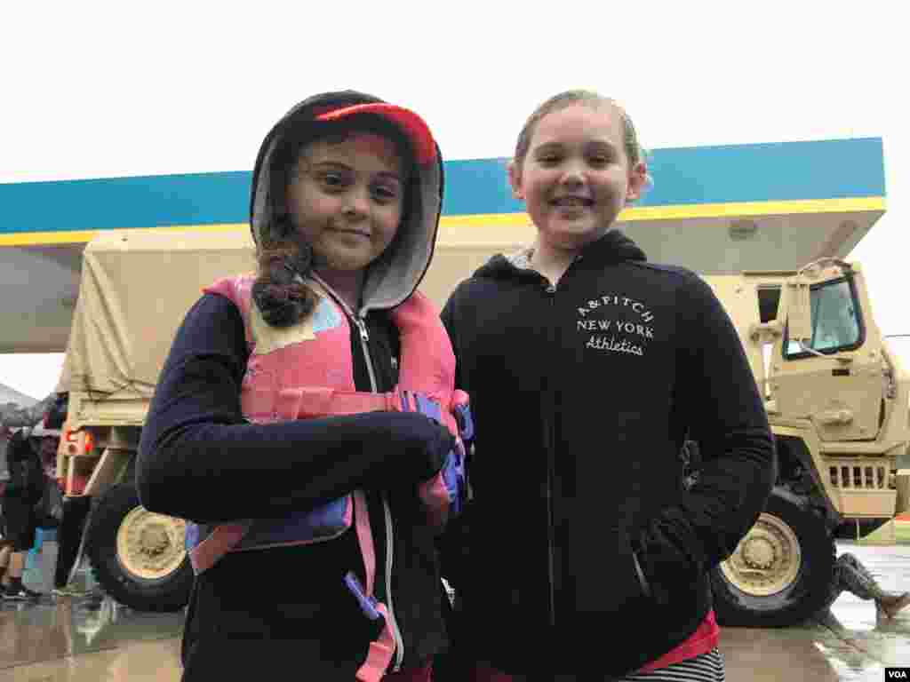 The Guel sisters – Sara, 7, at left, and Celeste, 8 – wait near the military transport truck that brought them from their flooded Greenbriar Colony neighborhood to a gas station transfer point in north Houston, Texas, Aug. 27, 2017. Next stop: a Red Cross
