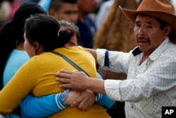 Familiares se abrazan afuera de un servicio funeral en Tula, estado de Hidalgo, en México, el sábado 19 de enero de 2019. Una bola de fuego envolvió a personas que extraían combustible de un oleoducto roto por ladrones, más de 70 murieron y decenas quedaron heridos.