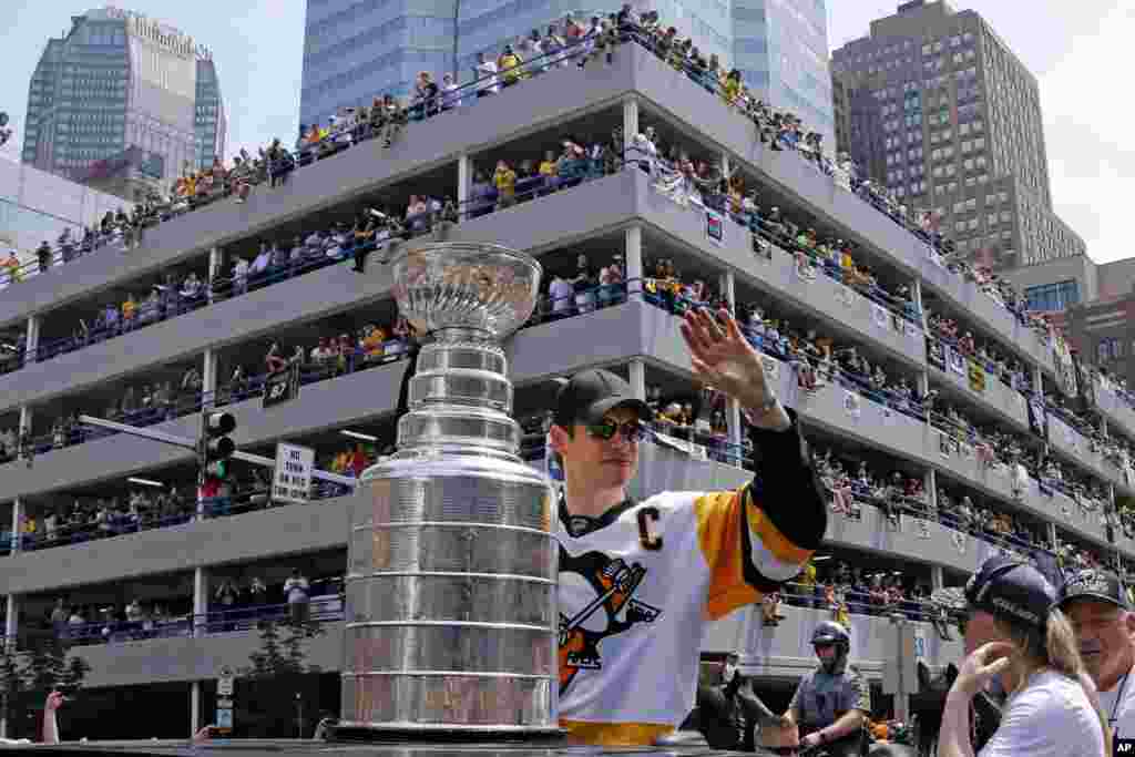 Warga kota Pittsburgh merayakan kemenangan klub hoki es Penguins yang baru saja menjuarai piala Stanley dalam parade di kota Pittsburgh, Pennsylvania.
