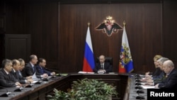 FILE - Russian President Vladimir Putin chairs a meeting with members of the Security Council at the National Defense Control Center in Moscow, Russia, March 11, 2016.