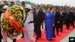 Vietnamese President Tran Dai Quang, center left, and his wife, center right, walk during a ceremony to pay respect at a statue of Cambodian late King Norodom Sihanouk, in Phnom Penh, Cambodia, Wednesday, June 15, 2016. Tran Dai Quang is on a two-day off