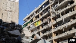 A Hezbollah flag flutters on one of the balconies of a building targeted by recent Israeli strikes in southern Beirut's Ruweiss district, Nov. 11, 2024, as the war continues between Israel and the Lebanese militant group.