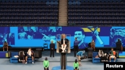 Serbia's Novak Djokovic and Taylor Fritz of the U.S. take a break during their third round match in Melbourne, Australia, Feb. 13, 2021 