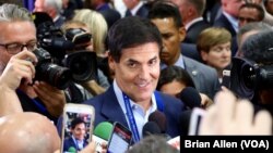 FILE - Billionaire Mark Cuban walks through the media filing center at Hofstra University, just prior to the first presidential debate in Hempstead, New York (B. Allen/VOA)