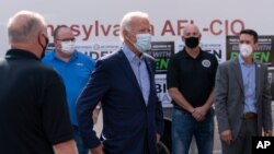 El exvicepresidente Joe Biden, candidato presidencial demócrata, habla con líderes sindicales después de tomar fotografías fuera de la sede de AFL-CIO en Harrisburg, Pensilvania, el lunes 7 de septiembre de 2020.