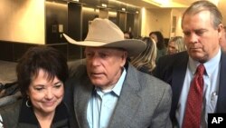 The words "Expect Us" are spray-painted on the base of the Andrew Jackson statue in Lafayette Park as Indigenous and environmental activists protest in front of the White House in Washington.