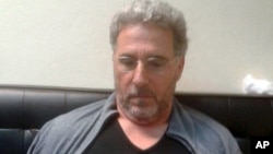 In this photo taken Sept. 3, 2017, a man identified by Italian Police as longtime fugitive Rocco Morabito looks down after being arrested in a Montevideo hotel, Uruguay.