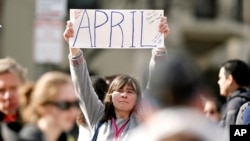 Cerca de la plaza Copley, Justine Franco, de Montpelier, Vermont, sostiene un letrero con el nombre de una amiga a la que no encuentra, April, que participaba en su primera maratón de Boston, el lunes 15 de abril de 2013.