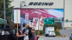 Stephanie Corona, anggota serikat pekerja Boeing, melambaikan tangan ke arah lalu lintas saat berdemo di pabrik Boeing di Everett, Washington, 13 September 2024. (Foto: John Froschauer/AP Photo)