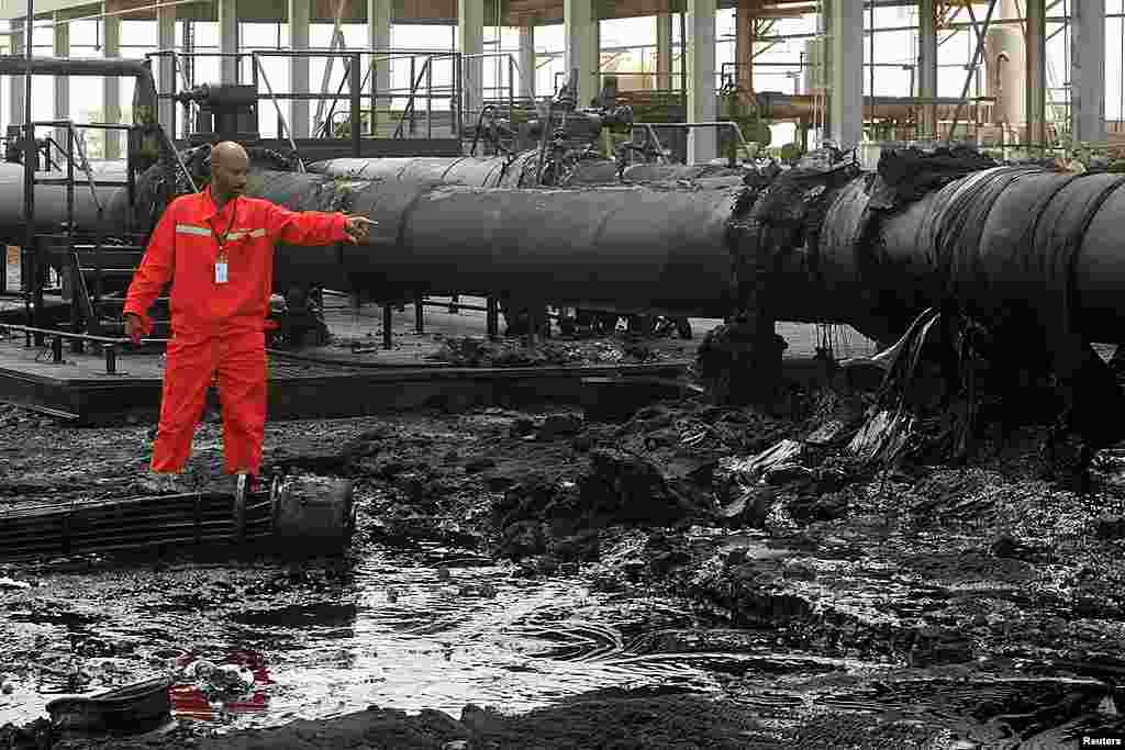 A Sudanese engineer points at the damage to an oil pipeline in a largely damaged oilfield in Heglig, April 23, 2012. (Reuters)