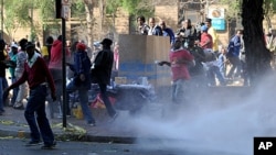 African National Congress Youth League (ANCYL) supporters flee water cannon fire as they took to the streets in downtown Johannesburg in support of leader Julius Malema who is facing a disciplinary hearing by senior ANC leaders. Malema is charged with bri