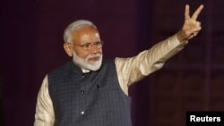 Perdana Menteri Narendra Modi mengacungkan tanda "V" (kemenangan) pada para pendukung partai berkuasa "Bharatiya Janata Party" (BJP) di New Delhi, India, Kamis (23/5). 