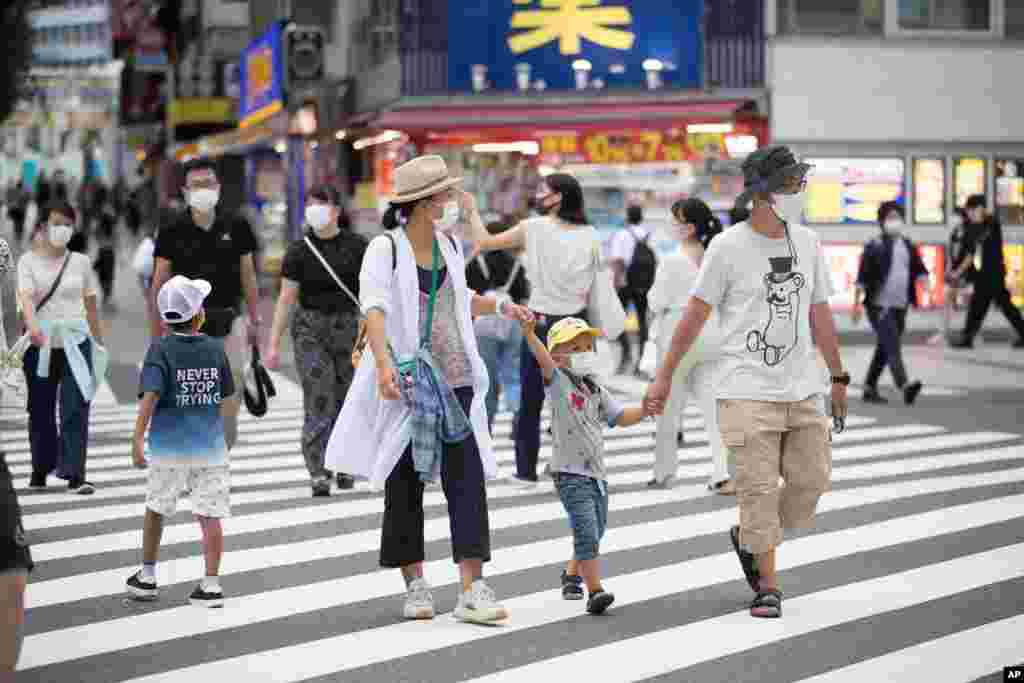 گروهی از مردم در پایتخت ژاپن با ماسک در حال عبور. با اینکه ژاپن از میزان تلفات پایین کرونا خبر داده اما اقتصاد این کشور با رکودی بی‌سابقه مواجه شده است. 