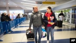FILE - Mohammed Hafar, left, helps his daughter Jana with her luggage as they leave JFK Airport in New York. 