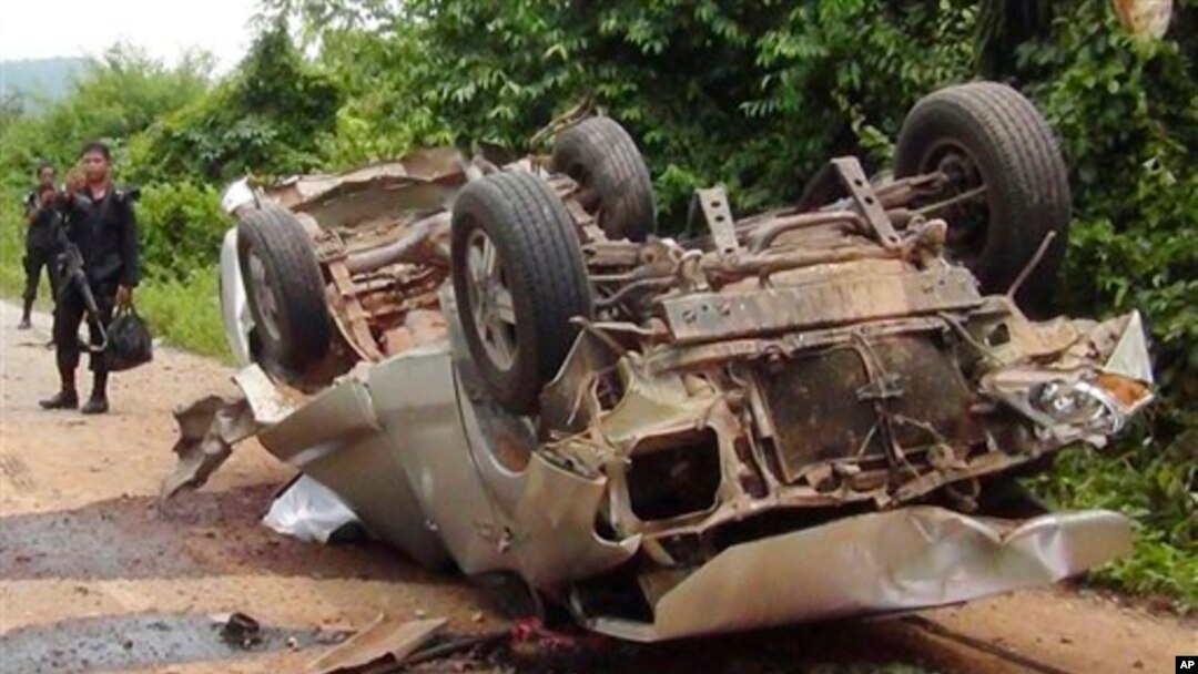 Seorang petugas berdiri di dekat truk yang hancur setelah melindas bom pinggir jalan di wilayah Saiburi, provinsi Pattani, Thailand (24/5). Dilaporkan lima tentara tewas dan satu terluka dalam insiden ini.