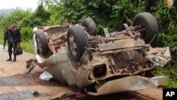 Seorang petugas berdiri di dekat truk yang hancur setelah melindas bom pinggir jalan di wilayah Saiburi, provinsi Pattani, Thailand (24/5). Dilaporkan lima tentara tewas dan satu terluka dalam insiden ini.