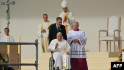 Pope Francis exits the stage on a wheelchair after a holy mass at King Baudouin stadium, in Brussels on Sept. 29, 2024. 