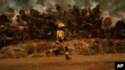 A firefighter runs to fight flames caused by wildfires in Santa Juana, Chile, Feb. 6, 2023. 