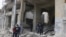 Residents inspect damage from what activists said was by warplanes loyal to Syria's President Bashar al-Assad in Jibb al-Quebeh neighborhood in Aleppo, April 11, 2015. 