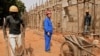 FILE - A Chinese foreman looks on as laborers work on the construction of military officers housing, donated by China, in Bissau, Guinea-Bissau, Jan. 3, 2007. 