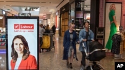 Shoppers walk past an electronic billboard showing a photo of New Zealand Prime Minister Jacinda Ardern in Christchurch, New Zealand, Wednesday, Oct. 14, 2020. Opinion polls indicate Ardern is on track to win a second term as prime minister in an…
