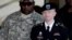 Army Pfc. Bradley Manning, right, is escorted out of a courthouse in Fort Meade, Maryland, June 25, 2012. 