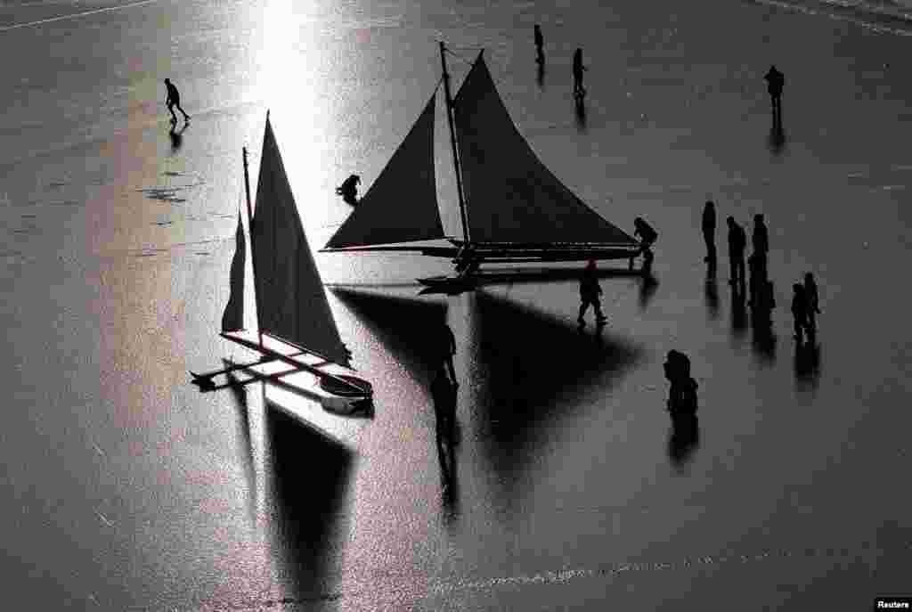 A drone view shows members of the Hudson River Ice Yacht Club prepare antique wooden ice sailing yachts, built during the late 1800s, on the frozen Hudson River near Athens, New York, Jan. 25, 2025.