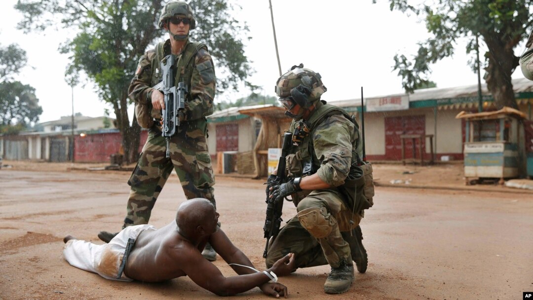 Dua tentara Perancis menahan salah seorang pendukung Seleka di Bangui (9/12). Perancis kehilangan dua tentaranya dalam pertempuran di Bangui. 