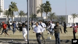 Bahraini anti-government protesters run for cover in Manama on February 19, 2011 after police fired tear gas to disperse them at Pearl Square