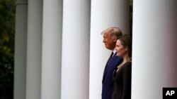 Presiden Donald Trump berjalan bersama Hakim Amy Coney Barrett untuk menghadiri konferensi pers untuk mengumumkan nominasi Barrett sebagai Hakim Mahkamah Agung, di Rose Garden, Gedung Putih, Washington, Sabtu, 26 September 2020.(Foto: AP)