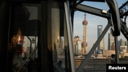 FILE - A bus moves past a bridge with the backdrop of the financial district of Pudong in Shanghai, China, Sept. 27, 2024