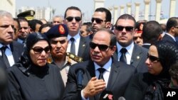 FILE - Egyptian President Abdel-Fattah el-Sissi, center, speaks at the funeral for Hisham Barakat, surrounded by the latter's family members, June 30, 2015.