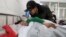 An elderly man talks to a girl who was injured after a stampede accident at a primary school, at a hospital in Xiangyang, Hubei province, China, Feb. 27, 2013.