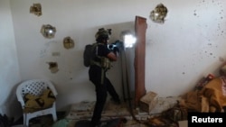 A member of the Iraqi Special Operations Forces (ISOF) takes his position during patrol looking for militants of the Islamic State, formerly known as the Islamic State of Iraq and the Levant (ISIL), in a neighborhood in Ramadi, July 23, 2014.