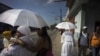 ARCHIVO - Mujeres vestidas de blanco caminan hacia una ceremonia en un mercado local para dejar ofrendas de hierbas en la religión yoruba "Santería" en La Habana, Cuba, el lunes 14 de septiembre de 2015.