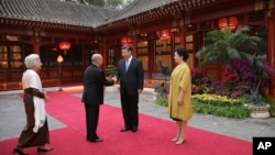 China's President Xi Jinping, center right, and his wife Peng Liyuan, right, welcome Cambodia's King Norodom Sihamoni, center left, and his mother former queen Monique, left, at Diaoyutai State Guesthouse Wednesday, Sept. 19, 2018, in Beijing, China. (Lintao Zhang/Pool Photo via AP)