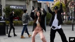 Jóvenes chinos bailan en las calles de Wuhan tras el levantamiento a la cuarentena de más de dos meses en que estuvo sumida la ciudad por el coronavirus.