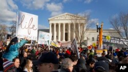 Anti-abortion demonstrators march past the Supreme Court in Washington, Thursday, Jan. 22, 2015.